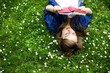 Woman lying on grass, reading book