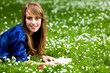Woman lying on grass with book