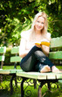 young woman reading book in park