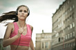 Young person listening misic running in city street Young person listening misic running in city street