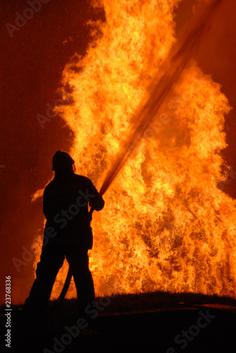 Photo: lone fireman battling against raging fire lone fireman battling against raging fire