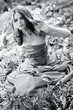 Young woman in dress sitting on grass