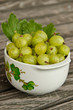 Bowl of freshly picked gooseberries on wooden table