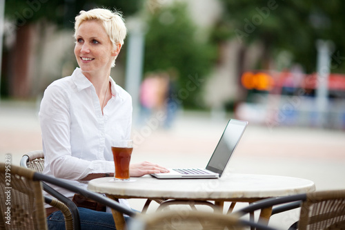 Foto: junge frau mit notebook im café junge frau mit notebook im café