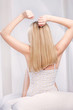 Blond hair woman stretching arms above head in bedroom