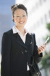 Young businesswoman using mobile outdoors  portrait