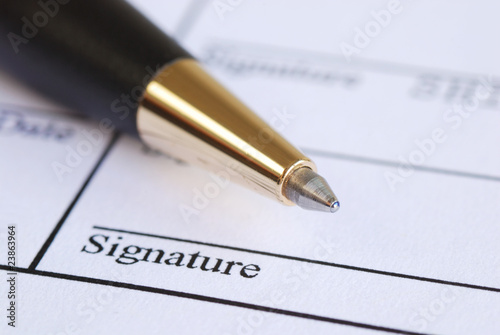 Photo: Sign the name on a paper with a pen Sign the name on a paper with a pen