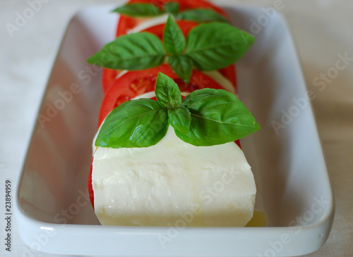 Photo: Caprese Salad with Fresh Basil on white background Caprese Salad with Fresh Basil on white background