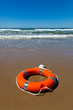 Red lifebuoy lying on the sand on the beach