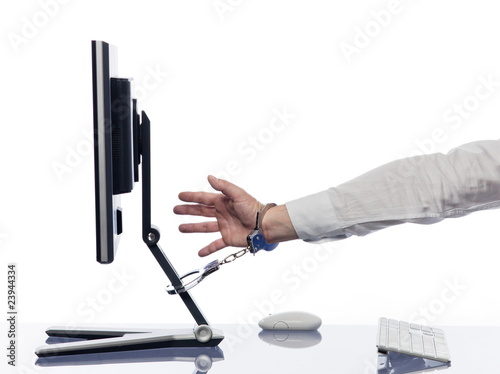 Photo: Hand chained to computer with handcuffs Hand chained to computer with handcuffs