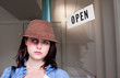 Attractive young woman with black-eye and open sign