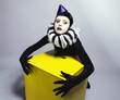Ñircus fashion mime posing near a yellow square on a grey backgr
