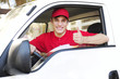 postal delivery courier in a van showing thumb up hand sign