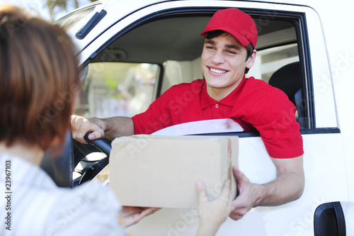 Photo: postal delivery courier in a van delivering package postal delivery courier in a van delivering package