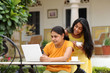 Photo: Loving mother and daughter with laptop in outdoors Loving mother and daughter with laptop in outdoors