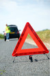 Photo: Red warning triangle with a broken down car Red warning triangle with a broken down car