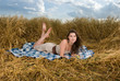 Beautiful slavonic girl on picnic in wheat field with apple