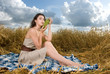 Beautiful slavonic girl on picnic in wheat field with grapes