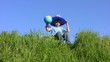boy in american flag hat sits on grass and holds globe