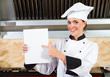 chef holding a white board or menu in kitchen