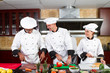 happy chefs cooking in industrial kitchen
