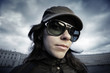 Photo: Funky young woman in cool sunglasses over dramatic cloudy sky Funky young woman in cool sunglasses over dramatic cloudy sky