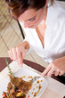 young woman eating steak in restaurant