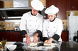 professional chefs hands kneading bread dough on a cutting board