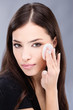 pretty black hair woman applying make up on her cheek pretty black hair woman applying make up on her cheek