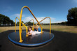Foto: Young girl and boy playing on roundabout Young girl and boy playing on roundabout