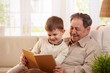 Grandfather reading book to grandson
