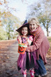 Grandmother hugging granddaughter in Halloween costume