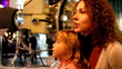 mother with daughter in space museum, space probe on backgrownd