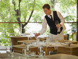 Waiter placing glasses on table in restaurant