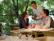 Waiter taking order from couple at restaurant table