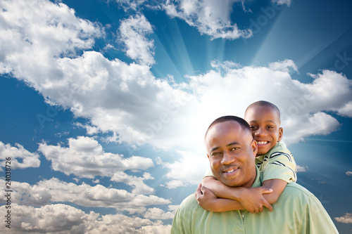 Photo: Happy African American Man with Child Over Clouds and Sky Happy African American Man with Child Over Clouds and Sky