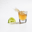 Close up of tequila splashing out of glass