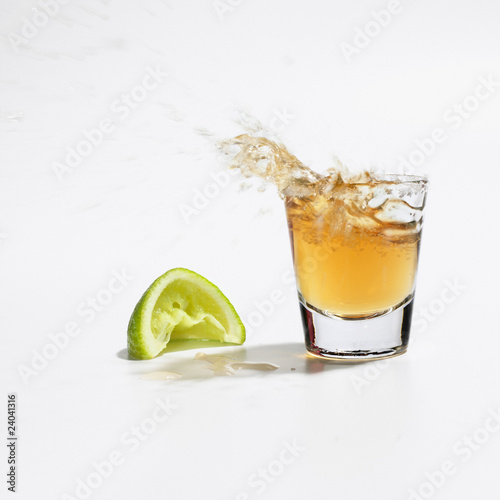Photo: Close up of tequila splashing out of glass Close up of tequila splashing out of glass