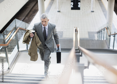 Foto: Businessman walking up stairs in train station Businessman walking up stairs in train station