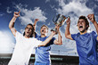 Soccer players cheering with trophy
