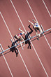 Runners jumping hurdles on track