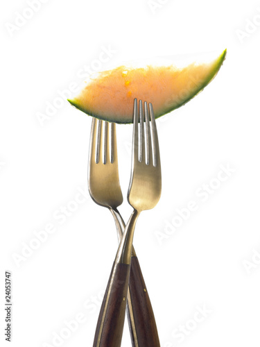 Photo: two forks with slice of melon two forks with slice of melon