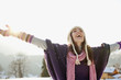 Woman with arms outstretched in snow