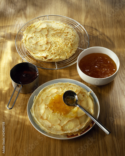 Foto: spreading the orange marmelade on the pancakes spreading the orange marmelade on the pancakes