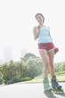 Woman on rollerblades looking at mp3 player