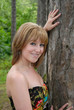 Pretty young woman posing against tree Pretty young woman posing against tree