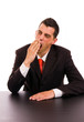 yawning young business man on the desk, on white background