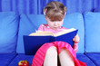 girl reading book with apple at sofa