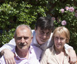 Photo: Parents and Son posing for Family Portrait in the Garden Parents and Son posing for Family Portrait in the Garden