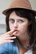 Young junkie woman smoking a cigar